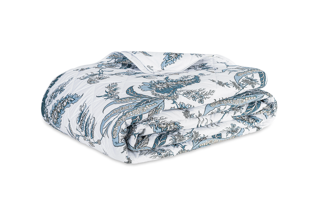 Apolline Quilted Coverlet designed by Schumacher. This botanical print evokes classic sophistication and grace. Sewn from 100% Egyptian cotton percale, boasting a Mediterranean blue floral pattern and silvery grey hues. Large diamond quilting and white piped edges add an exquisite touch.