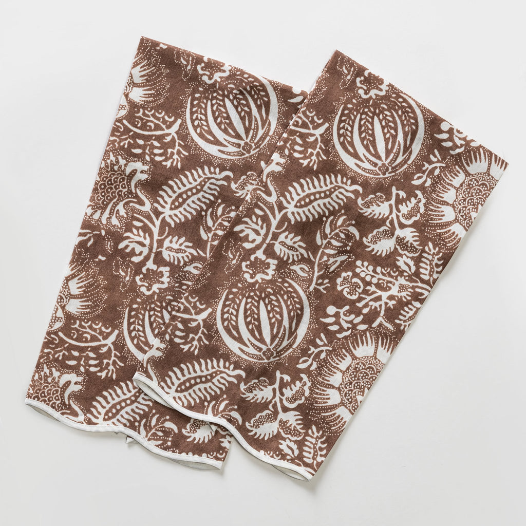 Matouk Schumacher Granada Linen Guest Towels in Chestnut Brown background with white pomegranate and botanical pattern