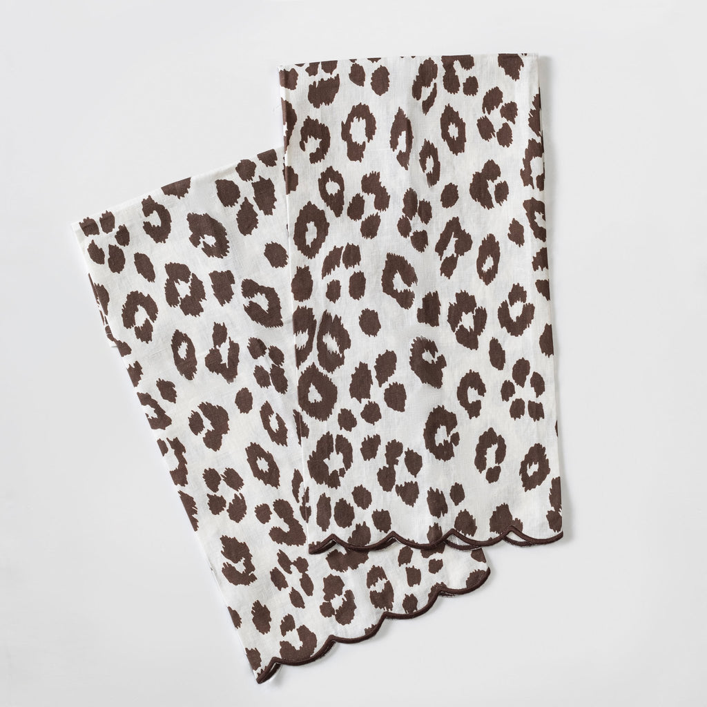 Matouk Schumacher Iconic Leopard Guest Towels in Cinder brown animal print on white linen background and brown embroidered scallop edge