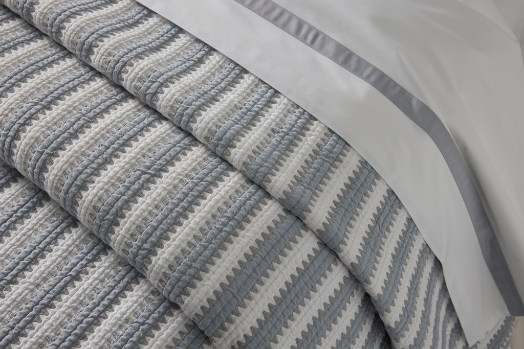 Expertly crafted in the USA with luxurious Italian fabric, Matouk's Apollo Stripe Matelassé coverlet and shams offer a comfortable and casual addition to your bedding. The 100% cotton shell and poly fill provide a minimal yet textural layer in a choice of Comet taupe or Dove blue & grey hues.