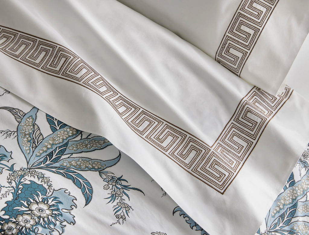 Introducing the Apolline Sheets, Duvet Covers + Shams by Matouk. Inspired by the graceful English countryside, this stunning botanical print features a white Egyptian cotton percale fabric with a Mediterranean blue floral pattern and silvery grey accents. With a subtle scallop edge, these sheets exude sophistication.