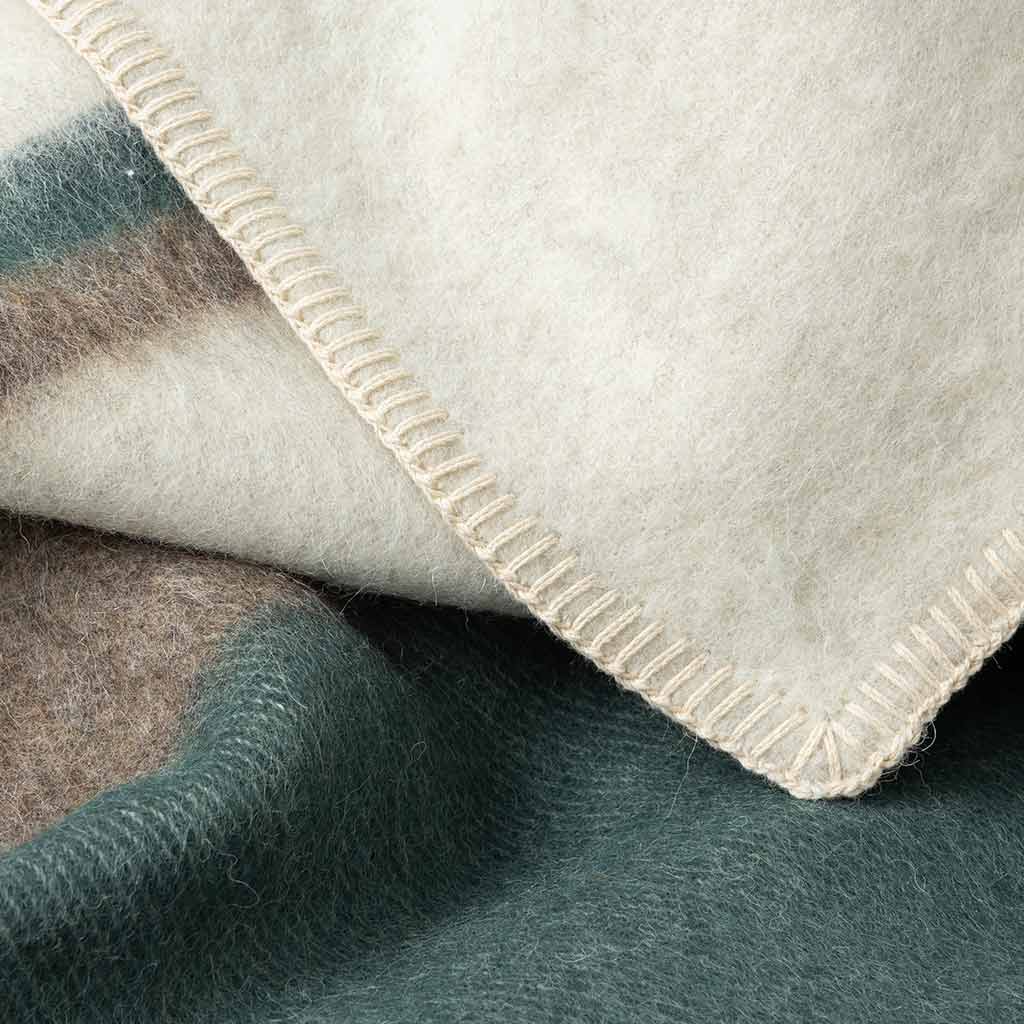 The Kimura Heirloom Blanket forest green, is a heavyweight mix of soft Alpaca and hypoallergenic Cotton fibers. Made with antique white blanket stitching and designed in Canada, this 100% natural fiber blanket is perfect for those who value quality and gentle materials. No harm to animals, just a cozy addition to your home.