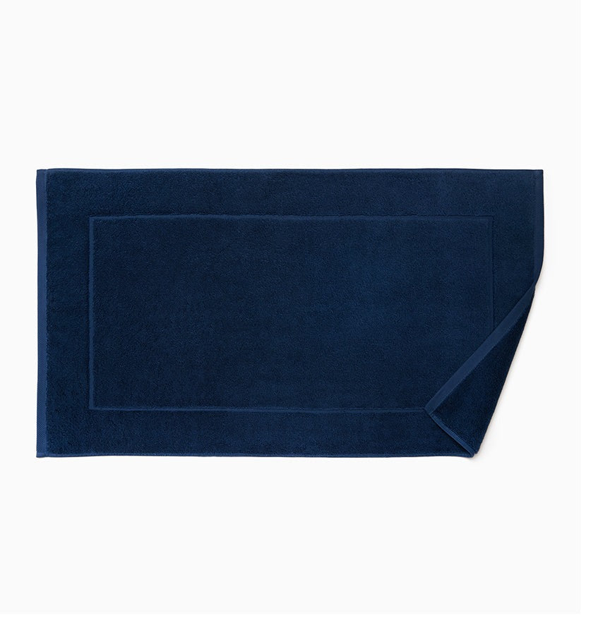 Experience the ultimate in comfort with Sferra's Cielo bath towels and tub mat. Made with the finest long staple cotton and zero-twist yarn, these towels are incredibly absorbent and feel weightless. The result? A heavenly softness that shines with a lustrous surface and catches the light. Indulge in luxury every time you use them. Ink dark Blue Tub Mat