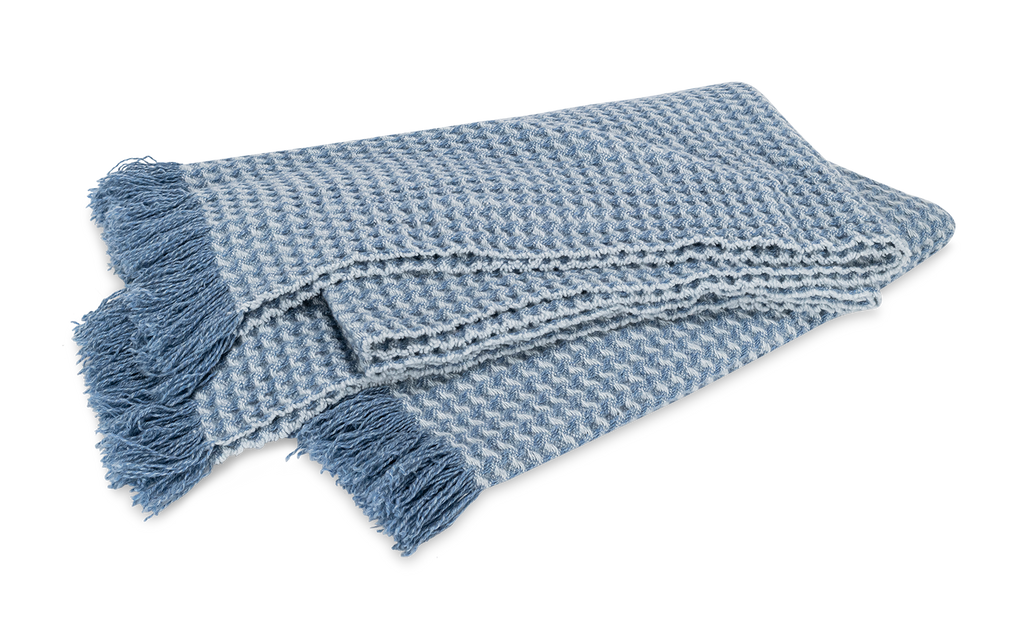 Indulge in pure luxury with the Cleo Cashmere Throw. Made from the softest 100% cashmere and washed using a special method, this oversized throw boasts extra loft and texture. With a subtle basket weave pattern, combed fringe, and understated monochromatic hues, Cleo adds elegant style to any home. Hazy Blue