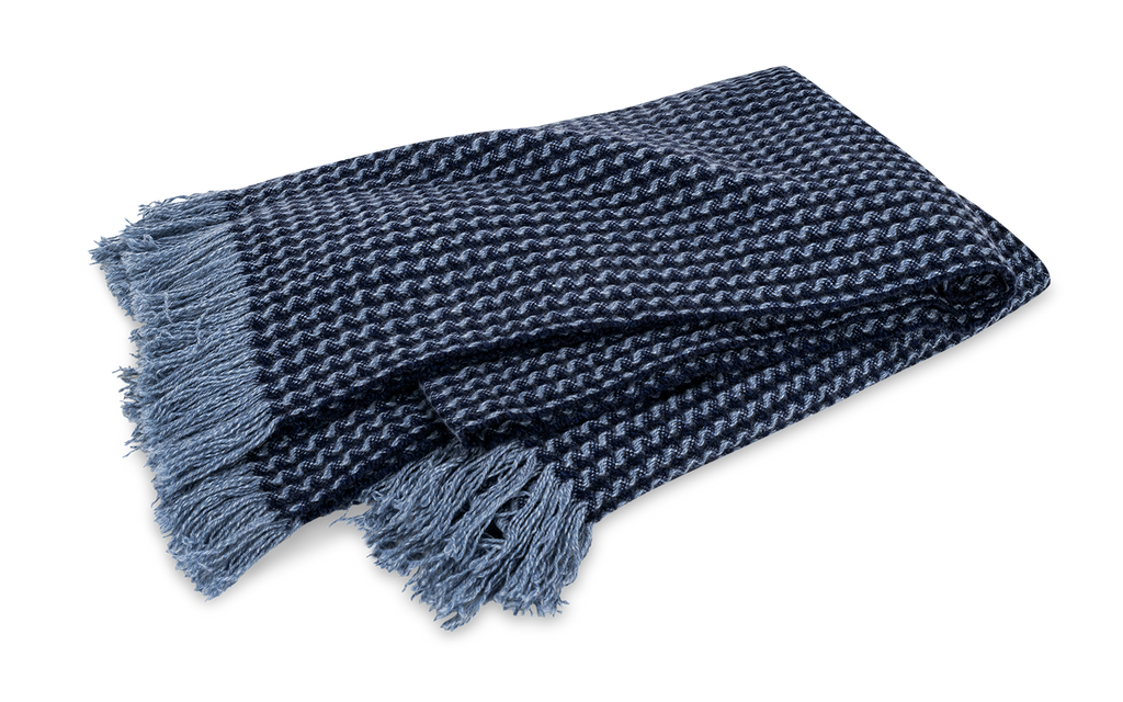 Indulge in pure luxury with the Cleo Cashmere Throw. Made from the softest 100% cashmere and washed using a special method, this oversized throw boasts extra loft and texture. With a subtle basket weave pattern, combed fringe, and understated monochromatic hues, Cleo adds elegant style to any home. Marine Blue