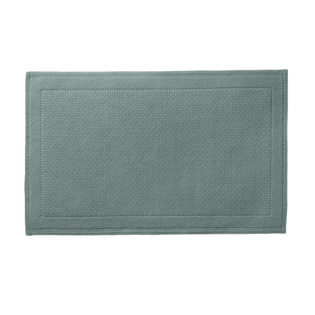 The Cosima Bath Rug boasts luxurious 100% long staple combed Turkish cotton for an incredibly soft and silky feel underfoot. The diamond pattern, featuring a tailored border and intricate jacquard woven details, adds a touch of elegance to any bathroom. Available in Alpine Green Blue 21x34