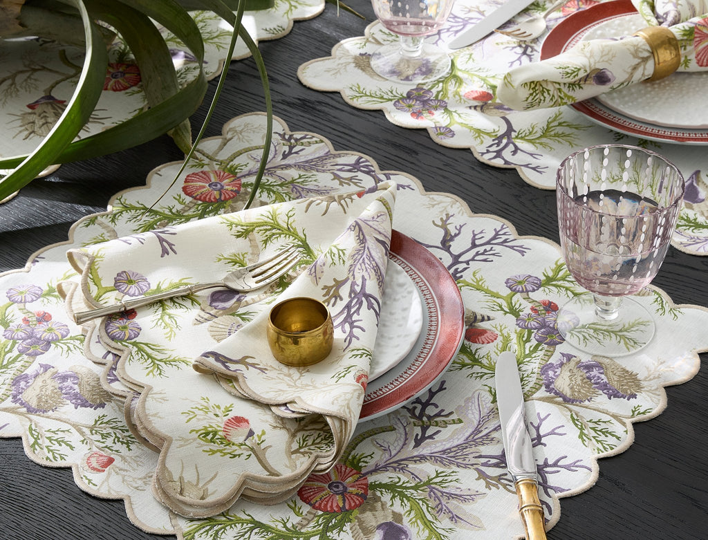 Matouk Schumacher Del Tesoro Linen Napkins, Placemats, Tablecloths, and Runners feature sea life and coral print on linen finished with a linen embroidered scallop edge