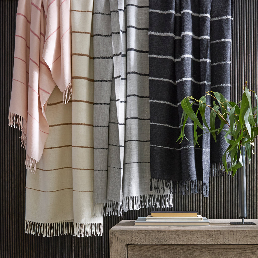 Introducing the Amelia Stripe Throw from Matouk. Wrap yourself in luxury with our lightweight and incredibly soft throw. Its basketweave pattern and fringe detailing exude elegance and sophistication. Made with 100% Baby Alpaca, it's the perfect travel companion for a cozy layer of warmth. Ethically made in Peru.