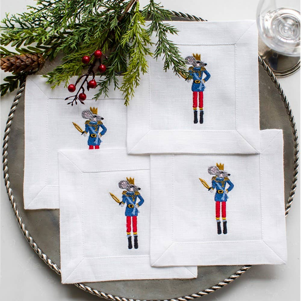 Enhance your table with our Nutcracker Mouse Cocktail Napkin Set made of 100% European white linen. Each napkin features a festive embroidered Nutcracker mouse and comes in a linen pouch, making it a perfect gift. Add elegance and charm to any gathering with this set of four 6" x 6" napkins. Cheers!