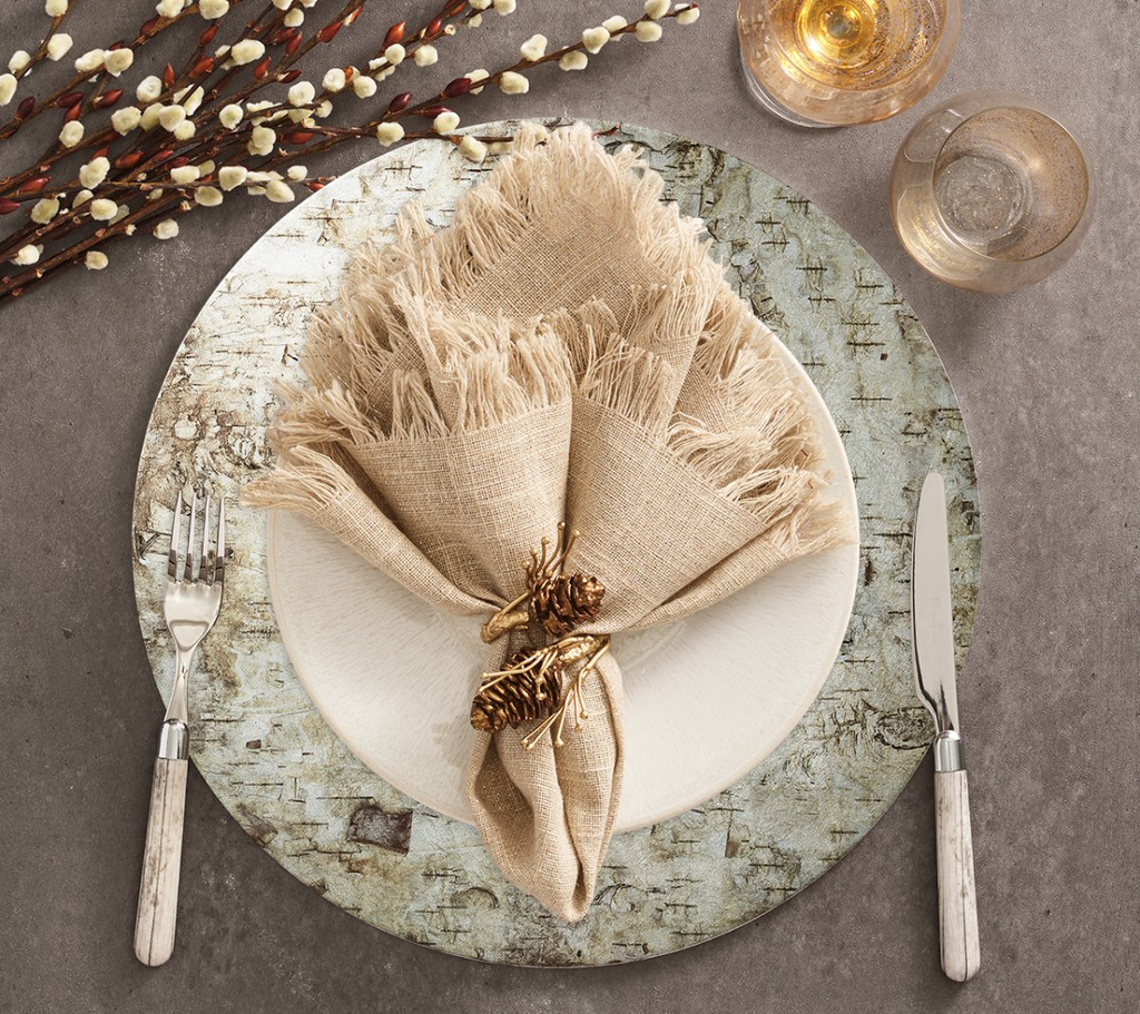 Elevate your table setting with the Chalet Placemat in Natural & Silver from Kim Seybert. The rustic birch bark image transferred onto a shimmering silver foil lacquered surface adds a touch of nature-inspired charm to any meal. Perfect for country or upscale settings, this placemat adds sophisticated, bucolic elegance to your dining experience.