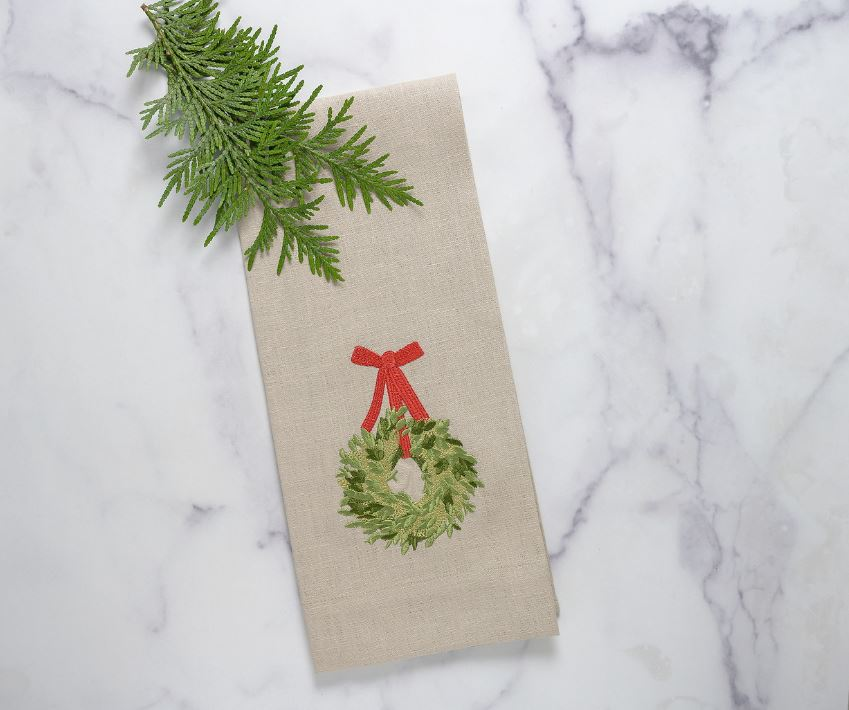 Crown Linens Boxwood Wreath Linen Towel. Crafted from 100% European flax linen, this luxurious towel features intricate embroidery of holiday greenery wreaths and red ribbons. Perfect for dressing up your kitchen or bath, this versatile towel adds a touch of elegance to any room. Made in Ukraine, measuring 17x29".