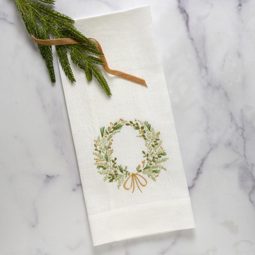 Add a touch of elegance and charm to your kitchen or bath with the Farmers Market Wreath Towel from Crown Linen Designs. Made from 100% European linen, this guest towel features delicate greenery embroidery and a golden sprig accent. At 17x29", it also includes a tab for easy hanging. Made in Italy for exceptional quality.