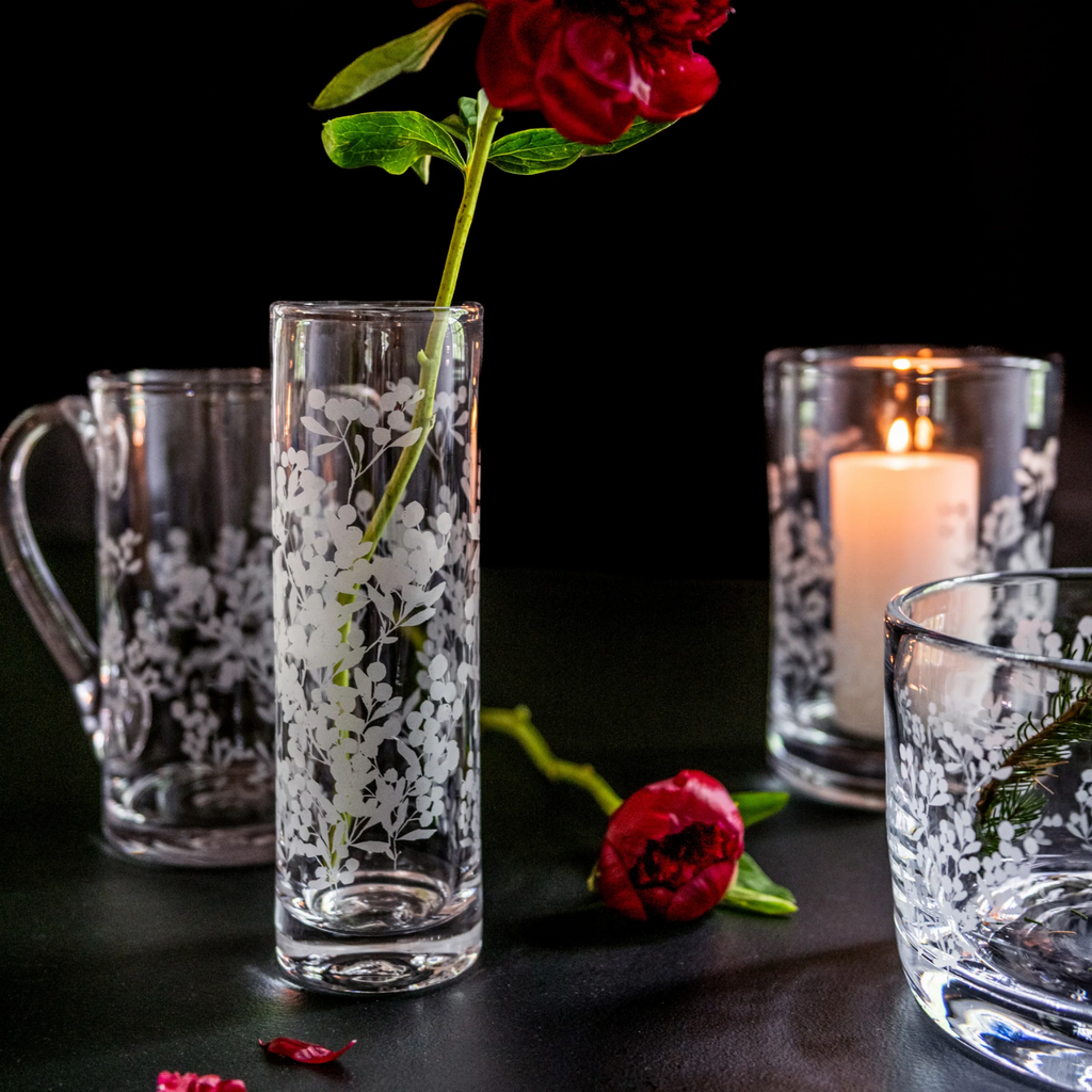 Crafted with precision and elegance, Simon Pearce's Engraved Berry Vase and hurricane is the perfect addition to any home decor. Made with high-quality materials, they feature intricate berry engravings that add a touch of sophistication to any space. Enjoy the beauty and functionality of this timeless piece.