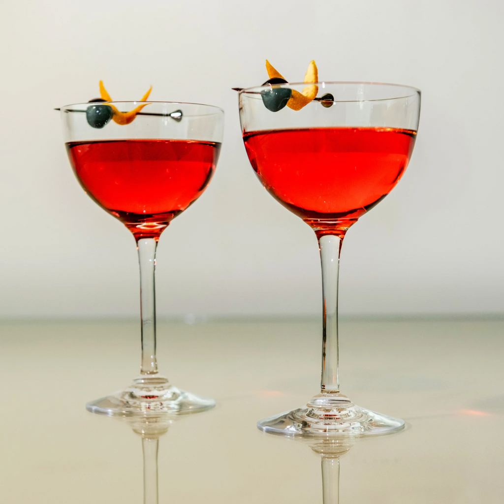 Indulge in the luxurious charm of the Vintner Nick & Nora Glass from Simon Pearce. Named after the iconic detectives, this glass features an upsized bowl for effortless mixing and sipping. With a thin rim and elegant stem design, it's perfect for your favorite cocktails.