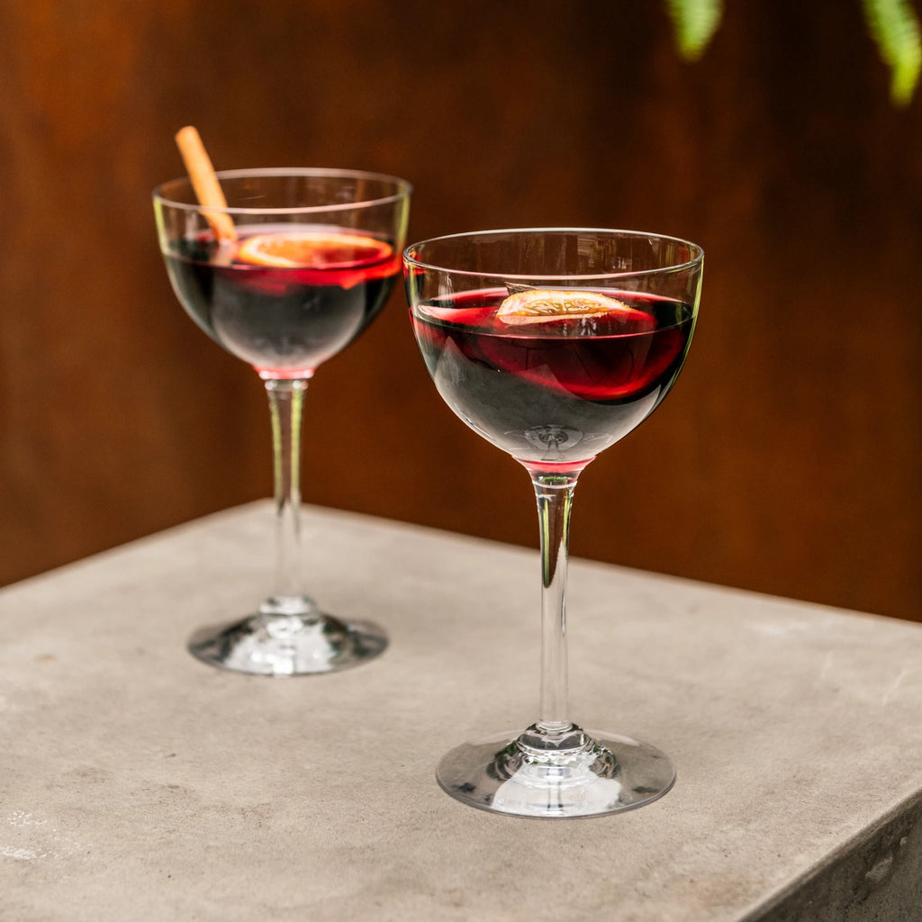 Indulge in the luxurious charm of the Vintner Nick & Nora Glass from Simon Pearce. Named after the iconic detectives, this glass features an upsized bowl for effortless mixing and sipping. With a thin rim and elegant stem design, it's perfect for your favorite cocktails.