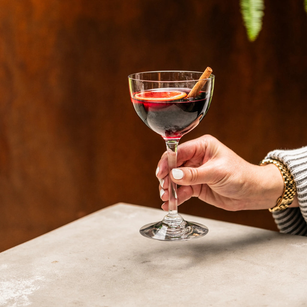 Indulge in the luxurious charm of the Vintner Nick & Nora Glass from Simon Pearce. Named after the iconic detectives, this glass features an upsized bowl for effortless mixing and sipping. With a thin rim and elegant stem design, it's perfect for your favorite cocktails.